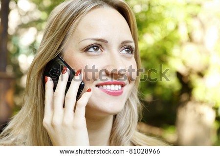 Outdoor portrait of young woman talk on mobile telephone.