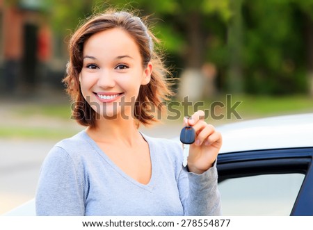 Happy girl with a car key smiling