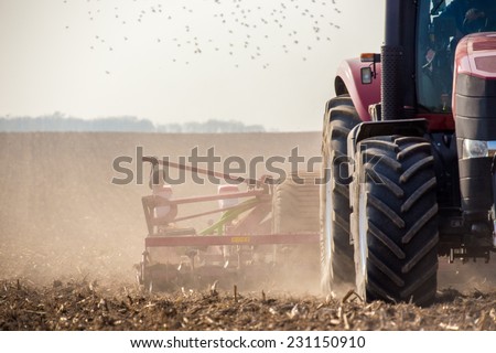 The tractor harvester working on the field