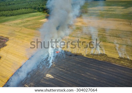 Aerial view on the fireman truck working on the field on fire