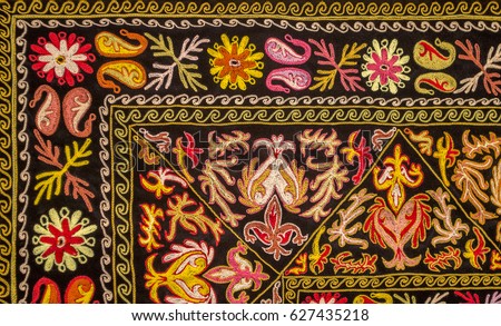 Colorful oriental embroidery pattern background. Floral ornament against black velvet. Kazakh fork art.