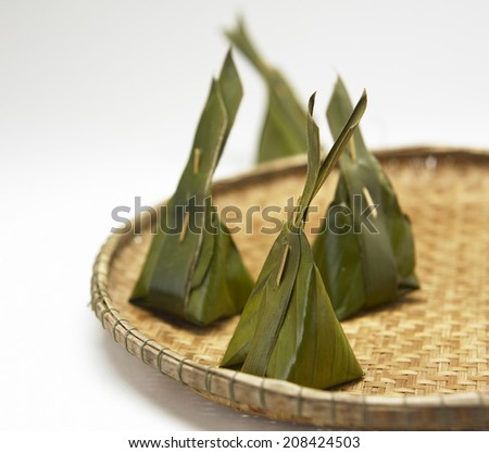Thai traditional sticky rice dessert in banana leaf packaging.