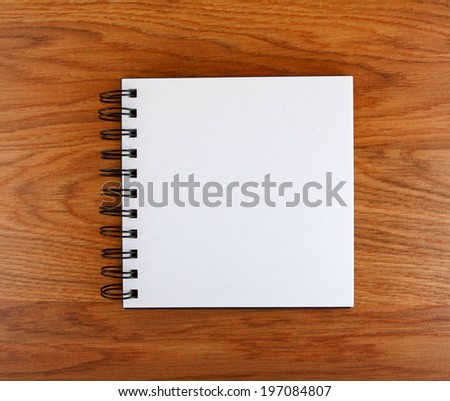 Notepad with a spiral binding on a wooden background