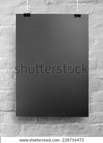 Black poster on a rope. Sheet of paper hangs on two black binder clips.