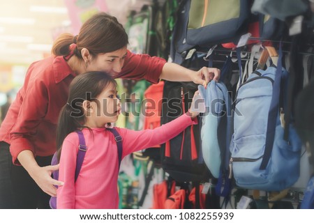 Back to school concept, Young asian mother or parent and little girl kid  buying school satchel or bag in store, Selective focus