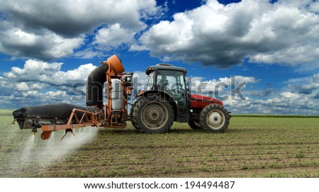 Tractor spraying soybean crops field with sprayer, pesticides and herbicides