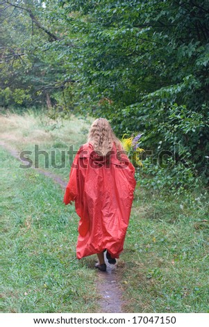 Young girl in red raincoat with yellow flowers go out