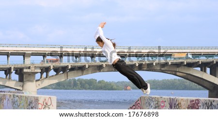 Tracer jumping in Kyiv of capital city of Ukraine. On background river Dniepr and Metro bridge