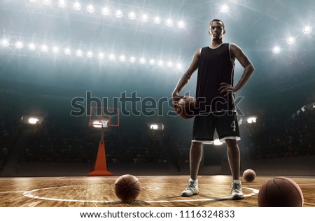 Young african american basketball player on professional basketball arena holding a ball
