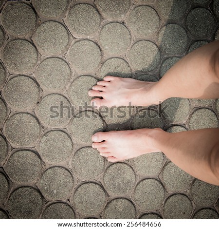 barefoot on patterned paving tiles, cement brick floor background