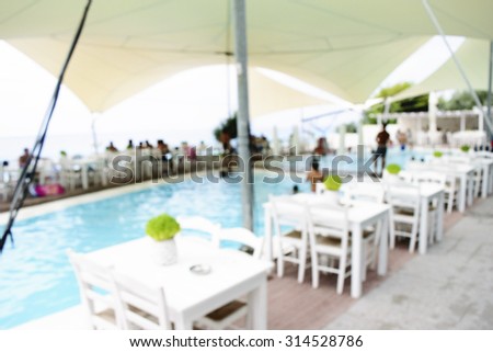 De focused or blurred view of armchair and table on the beach for recreation background