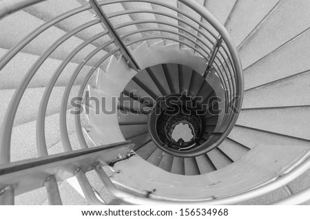 Looking down at a spiral staircase, black and white photo.