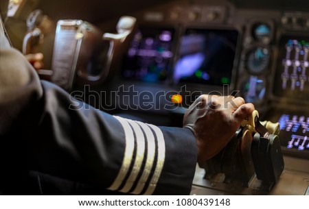 Cropped Hands of African Pilot flying a commercial airplane, cockpit view close up of hands