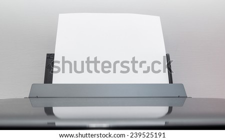 Blank sheets of paper coming out of an computer printer.