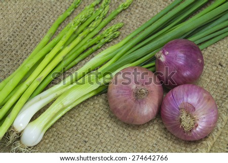 Asparagus, Onion and spring onion on sack background