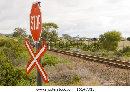 A stop sign at a railroad crossing, indicating a single rail to be crossed.