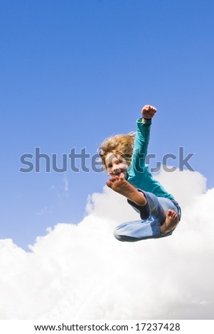 A little girl jumping into the air, performing antics while trying to do some martial art movements while airborne.