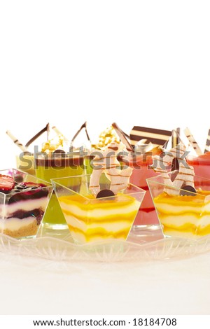 An assortment of colorful mousse desserts in cups.