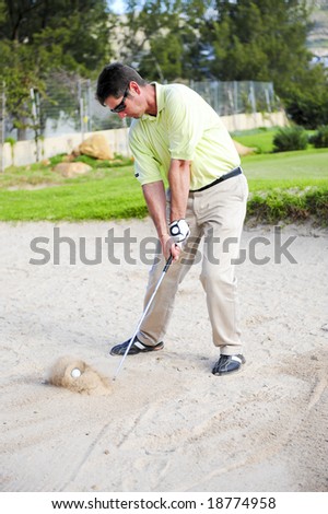 A professional golfer playing a shot out of a sand-trap with excellent control.