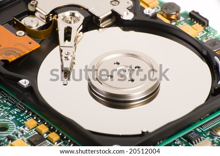 A close up inside of a hard disk drive, showing the disk surface and drive head. Some IC's are also visible.