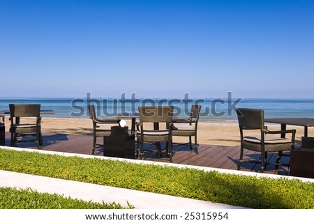Romantic restaurant setting on a deck next to the beach.