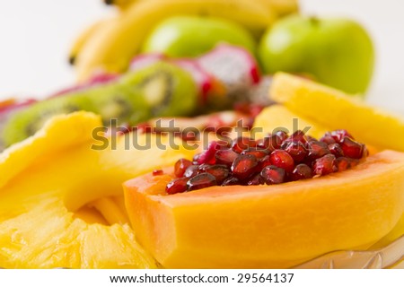 Delicious freshly cut fruit salad with pomegranate seeds inside a papaya and other fruit.