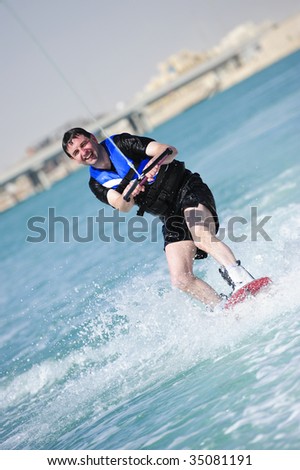 A wake boarder enjoying the action of riding the wake of the boat.