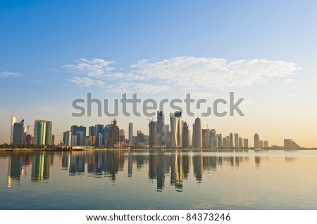 Arabian city of Doha Qatar, where the skyline changed drastically over the past 5 years. Image captured early in the morning with the sun rising from the right and some rare fluffy clouds in the sky..