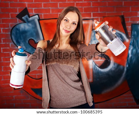 Woman with body art against graffiti brick wall.