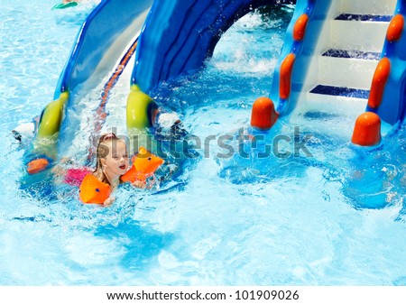 Child with armbands in swimming pool. Summer outdoor.