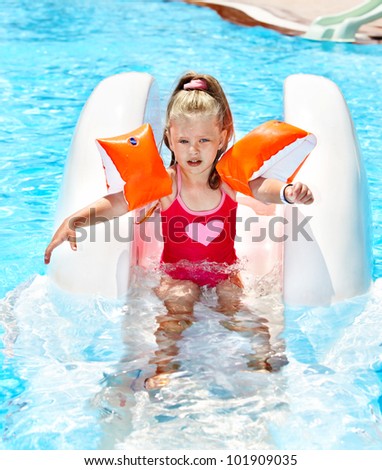 Child on water slide at aquapark. Summer outdoor.