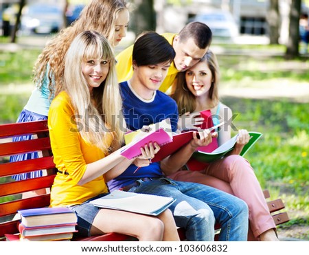 Group student with notebook on bench outdoor.