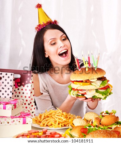 Woman eating hamburger at birthday.