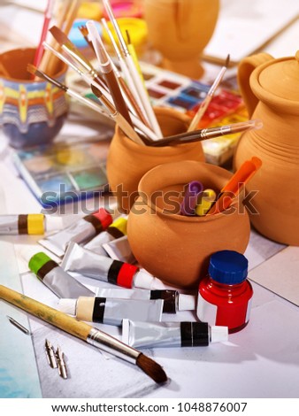 Authentic paint brushes still life on table in art class school as drawing course. Group of brush in clay jar. Discounts on goods for artists.