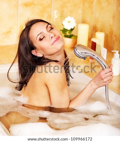 Young happy woman take bubble  bath.