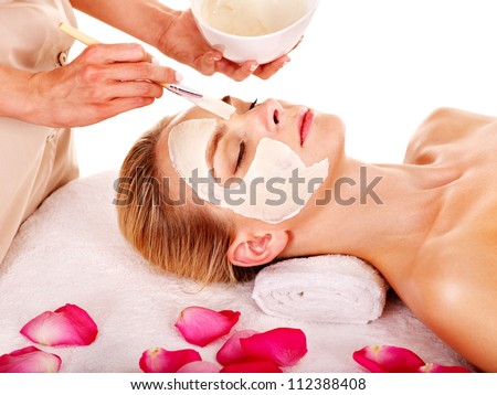 Woman with clay facial mask with rose petal. Isolated.