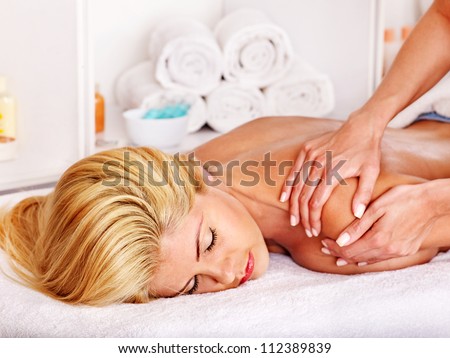 Blond woman getting massage in health resort.