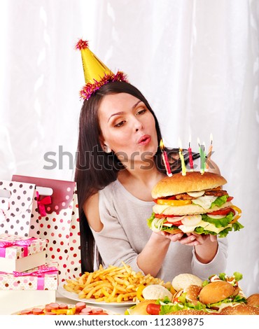 Woman  eating hamburger at birthday. Concept.