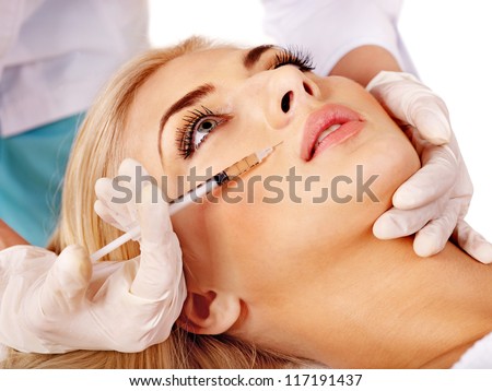 Doctor woman giving botox injections. Isolated.