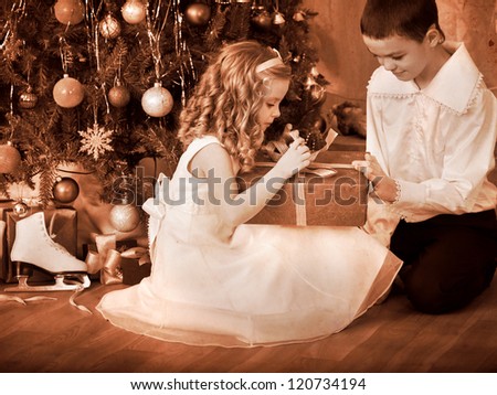 Children  receiving gifts under Christmas tree. Black and white retro.