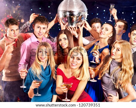 Group people with  champagne dancing at party. Disco ball.