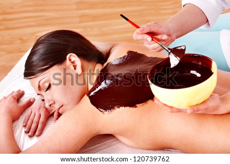 Beautiful girl having chocolate facial mask apply by beautician Beautiful girl having chocolate facial mask apply by beautician