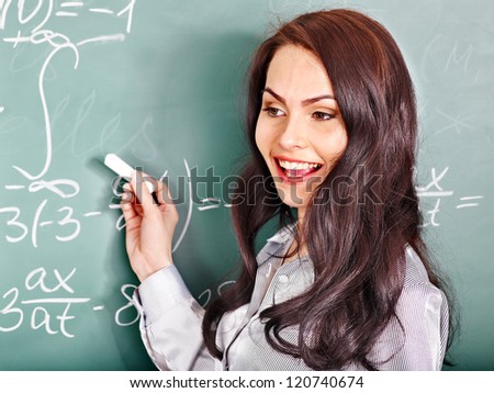Happy schoolchild writing on blackboard.