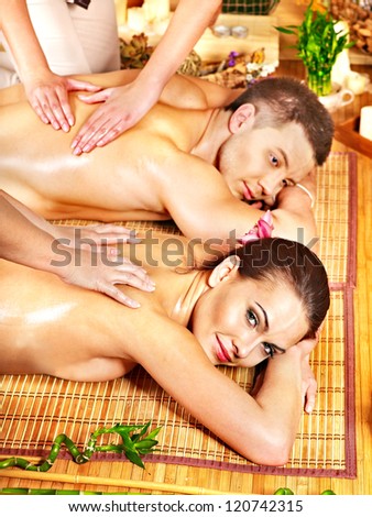 Man and woman relaxing in bamboo spa.