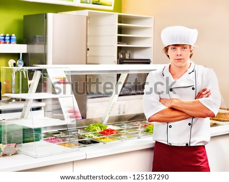 Male chef wearing uniform at cafeteria.