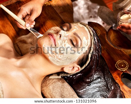 Woman having facial mask at ayurveda spa.