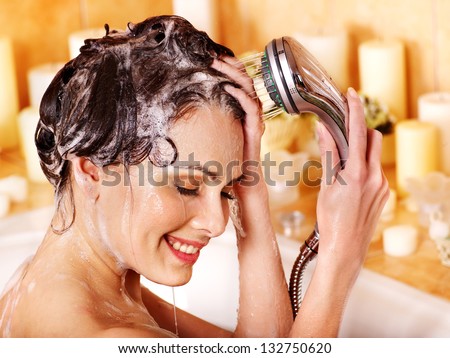Woman washes her head at home bathroom.