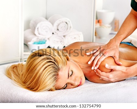 Blond woman getting massage in health resort.