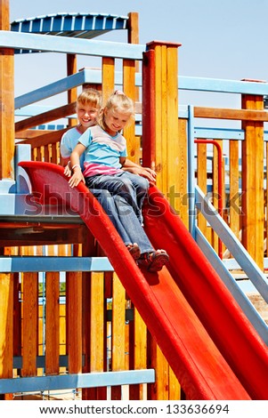 Happy children move out to slide in playground.