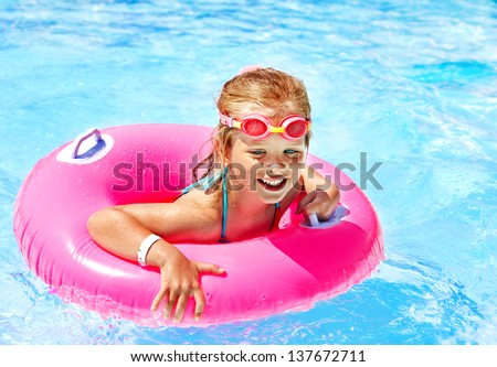 Children Sitting On Inflatable Ring In Swimming Pool.